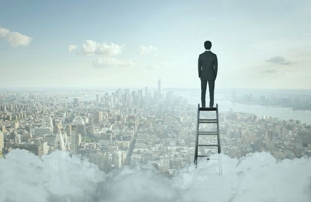 homem de negócios no topo da escada, observando a paisagem de uma cidade com ar de poluição.